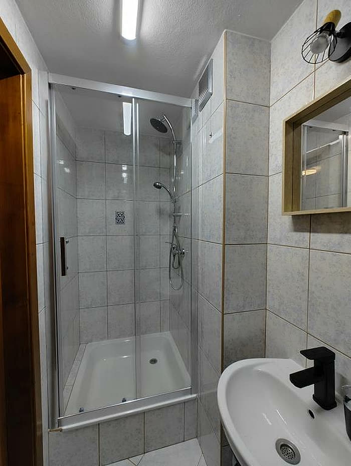 Jasna łazienka z prysznicem i umywalką