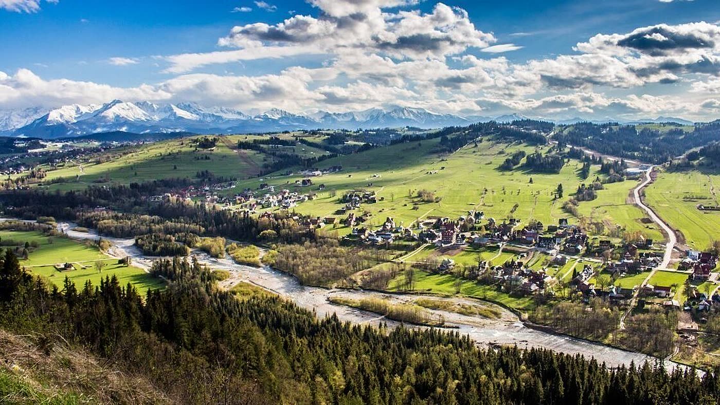 Panorama Białki Tatrzańskiej — dolina rzeki Białki, zabudowa wsi i ośnieżone Tatry na horyzoncie