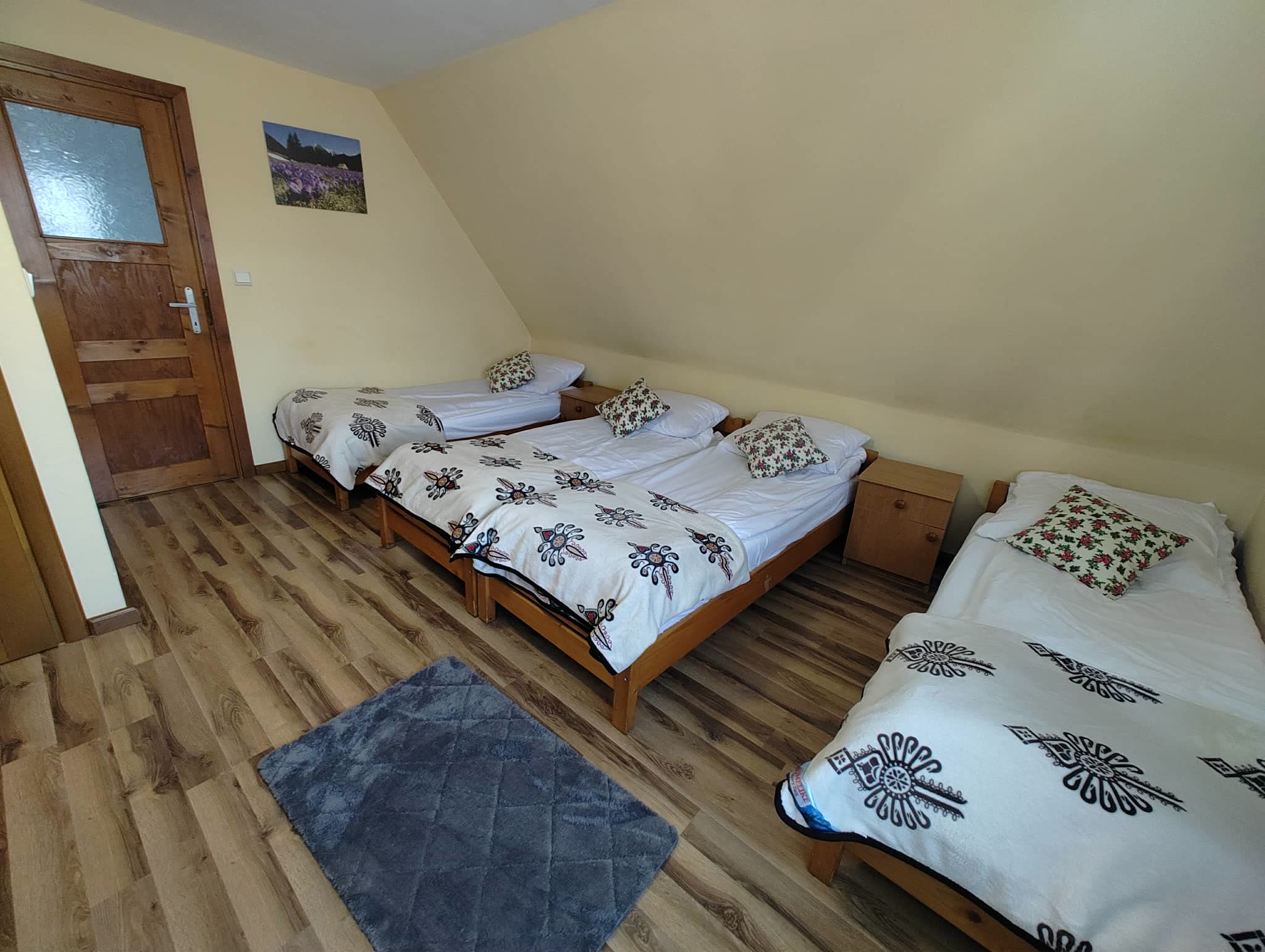Pokój czteroosobowy nr 3 — wejście do pokoju i dywan