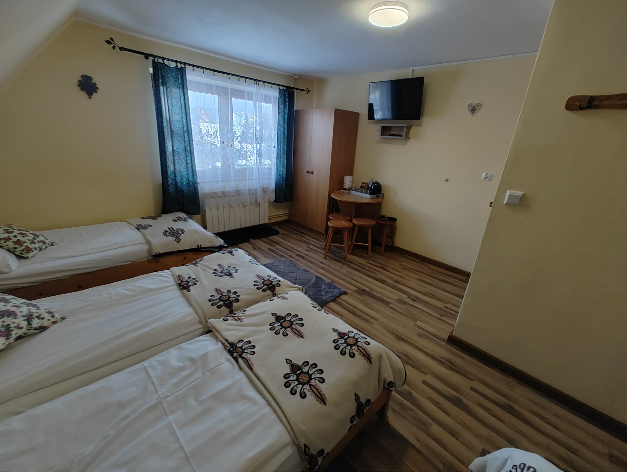 Pokój czteroosobowy nr 3 — telewizor i miejsce do siedzenia