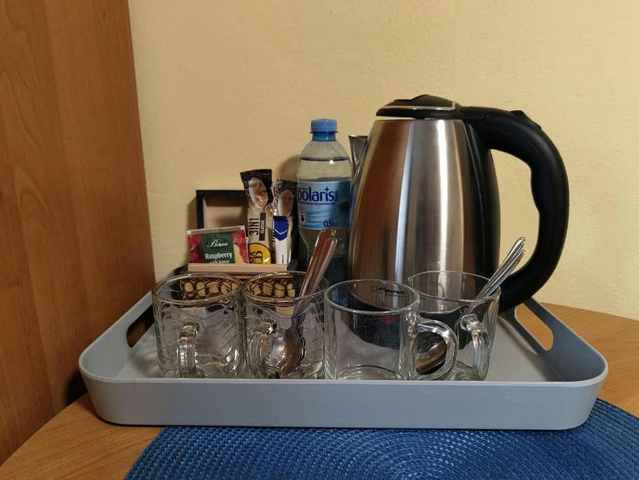Taca powitalna w pokoju: czajnik, kawa, herbata i woda mineralna